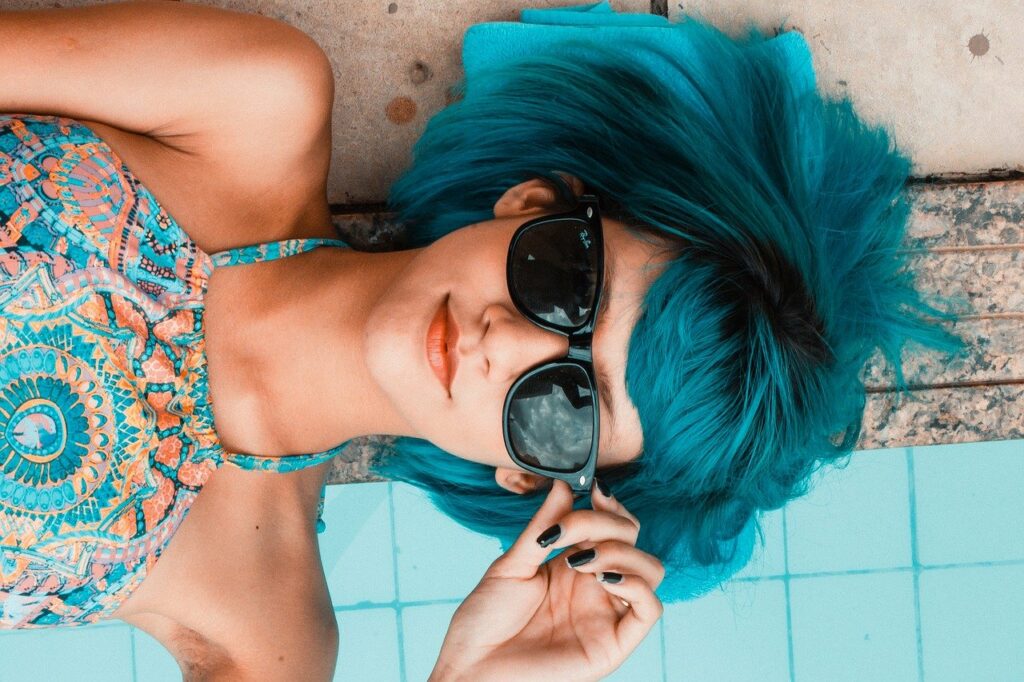 Selbstbewusst in Kleidung fühlen Frau Pool Sonnenbrille blaue Haare