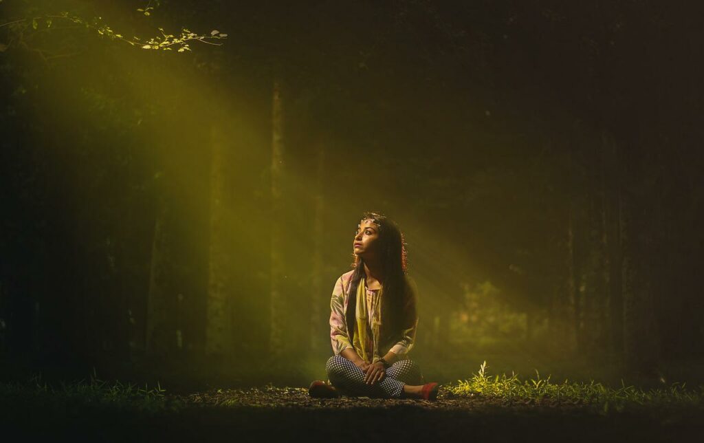 Frau sitzt im Wald Erleuchtung Curryblätter für das Haarwachstum