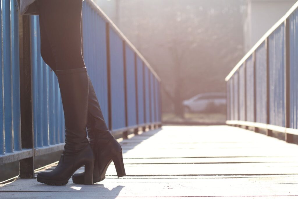 Frau Sonne Urlaub lange schwarze Stiefel hohe Absätze Elegante Stiefel-Looks für Damen im Sommerurlaub
